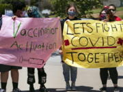 San Pedro High School students hold vaccination signs at a school-based COVID-19 vaccination event for students 12 and older in San Pedro, Calif., Monday, May 24, 2021. Schools are turning to mascots, prizes and contests to entice youth ages 12 and up to get vaccinated against the coronavirus before summer break.