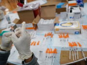 FILE - In this April 8, 2021, file photo, a Northwell Health registered nurses fills a syringe with the Johnson & Johnson COVID-19 vaccine at a pop up vaccination site at the Albanian Islamic Cultural Center in the Staten Island borough of New York. The Biden administration on Wednesday, May 5,  joined calls for more sharing of the technology behind COVID-19 vaccines to help speed the end of the pandemic, a shift that puts the U.S. alongside many in the developing world who want rich countries to do more to get doses to the needy.