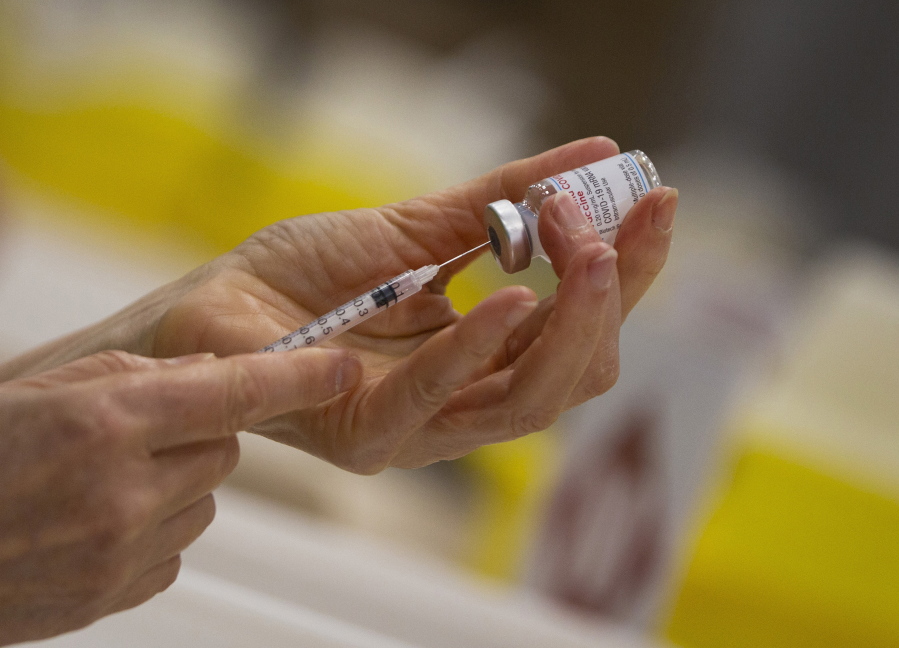 FILE - In this file photo dated Wednesday, April 14, 2021, a pharmacist fills a syringe from a vial of the Moderna COVID-19 vaccine in Antwerp, Belgium.  Moderna and vaccine promoter Gavi have announced Monday May 3, 2021, the pharmaceutical company will provide up to 500 million coronavirus vaccine doses for the U.N.-backed program for needy people in low- and middle-income countries by the end of 2022.