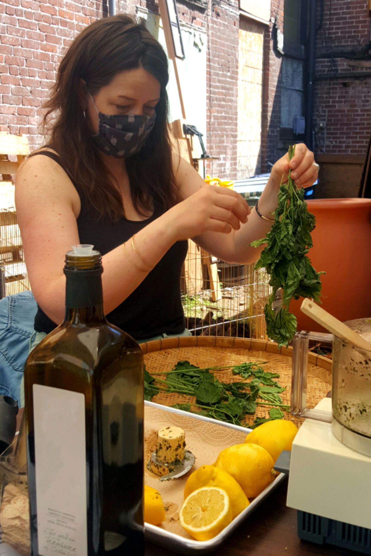 Self-described "folk herbalist" Emily Reudink teaches students how to make nettle pesto at an outdoor workshop at Kindred Homestead Supply.