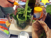 Emily Reudink puts the ingredients for nettle pesto into a food processor during a recent workshop about nettles.