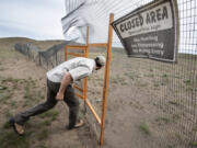 Jon Gallie, pygmy rabbit biologist for the Washington Department of Fish and Wildlife, enters the rabbit breeding enclosure in April that was destroyed along with all the rabbits in a 2020 wildfire, setting back the breeding program for years.