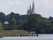 In the shadow of the Magic Kingdom, Florida Fish and Wildlife Conservation officers search for a young boy June 15, 2016, after the boy was grabbed by an alligator at Grand Floridian Resort at Disney World near Lake Buena Vista, Fla. Since the incident, around 250 alligators have been removed from Disney properties.