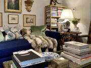 The brass and glass coffee table holds favorite books while allowing the leopard rug to make its presence known in Jim Miller's chic and charming home. Scottish roebuck antlers draw the eye up and add height.