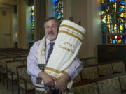 Rabbi Leonard Sarko, of Congregation Emanu-El Israel, holds a Sefer Torah done in braille June 8 at the Congregation Emanu-El Israel in Greensburg, Pa.