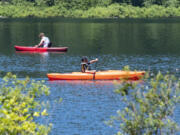 Kayakers paddle on the water Saturday at Battle Ground Lake State Park.