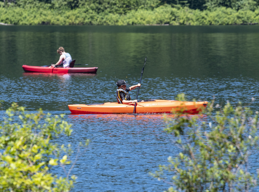 Kayakers paddle on the water Saturday at Battle Ground Lake State Park.