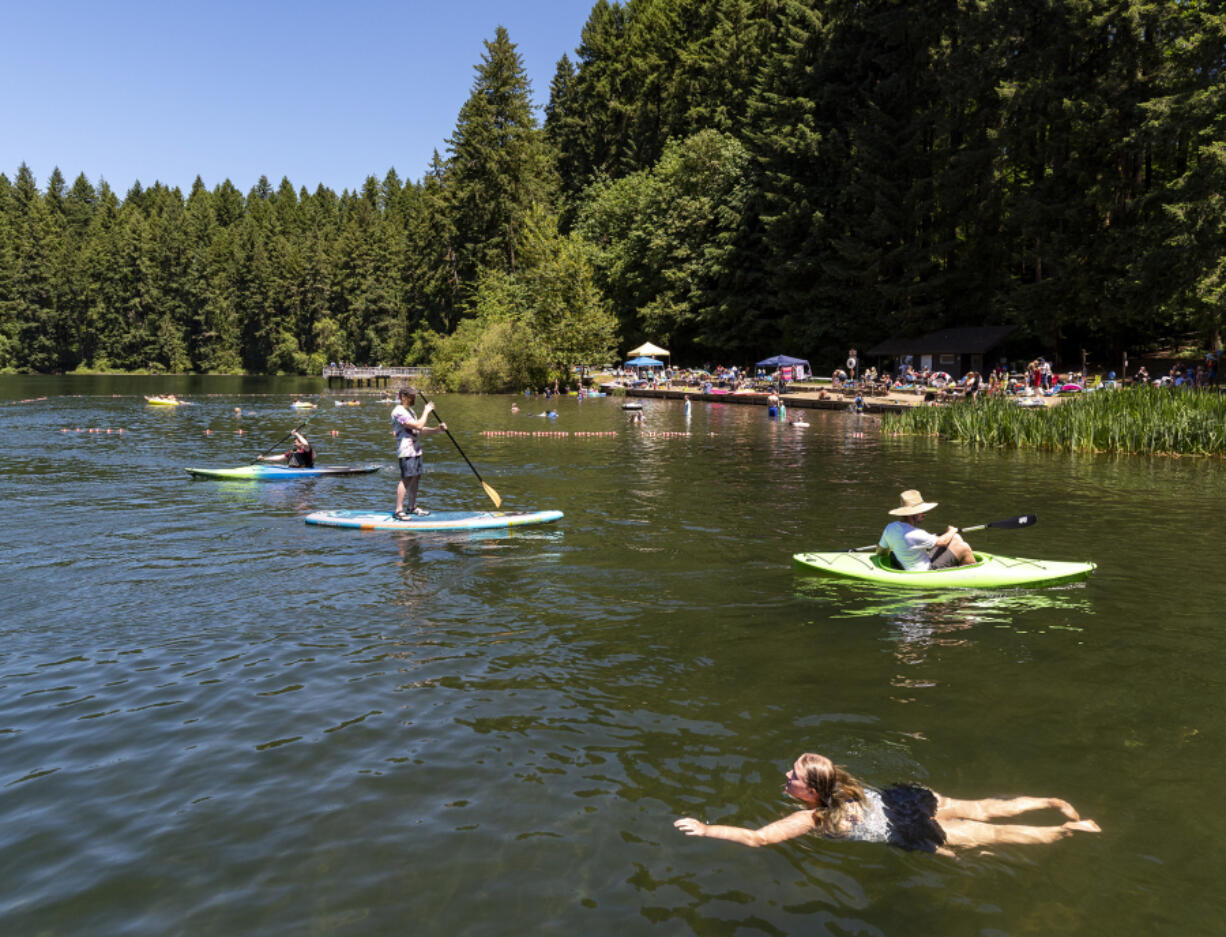 Swimmers, kayakers and stand-up paddleboarders enjoy an afternoon on the water Saturday at Battle Ground Lake State Park.