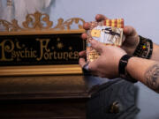 Employee Ryan Thiessen shuffles a tarot card deck at Love Potion Magickal Perfumerie in downtown Vancouver. "We're a spiritual place but we mix in fantasy and nerd culture," said store owner Mara Fox, who reinvented her life after making it big in the band Precious Metal.