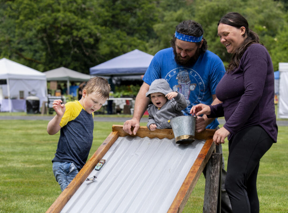 From left: Five-year-old Jacob Mosbach, 11-month-old Maeve DeGrandpre, Adam DeGrandpre and Jemima Dockery play with toy cars during Pomeroy Farm's Farm Days on Saturday in Yacolt. The event gives guests a chance to view the historic grounds and visit with farm animals, artisans and vendors. Farm Days runs the first weekend of each month through August.