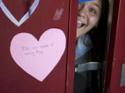 BATTLE GROUND: Prairie High School sophomore Soledad Ahumada peeks out from a door holding a heart with an inspirational message.