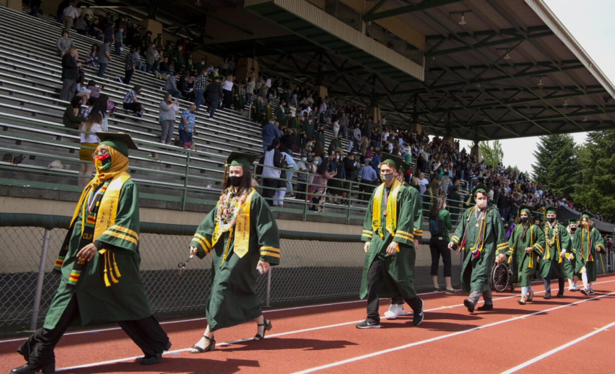 Evergreen High School graduates walk along the track during their graduation ceremony Saturday at McKenzie Stadium.