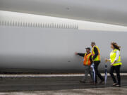 ILWU Local 4 President Cager Claybaugh talks to Gov. Jay Inslee while they walk alongside a wind turbine blade with Port of Vancouver CEO Julianna Marler on Tuesday at the Port of Vancouver. Inslee visited the Port to view an in-progress shipment of wind turbine blades that are coming through Vancouver on their way to Wasco, Ore.