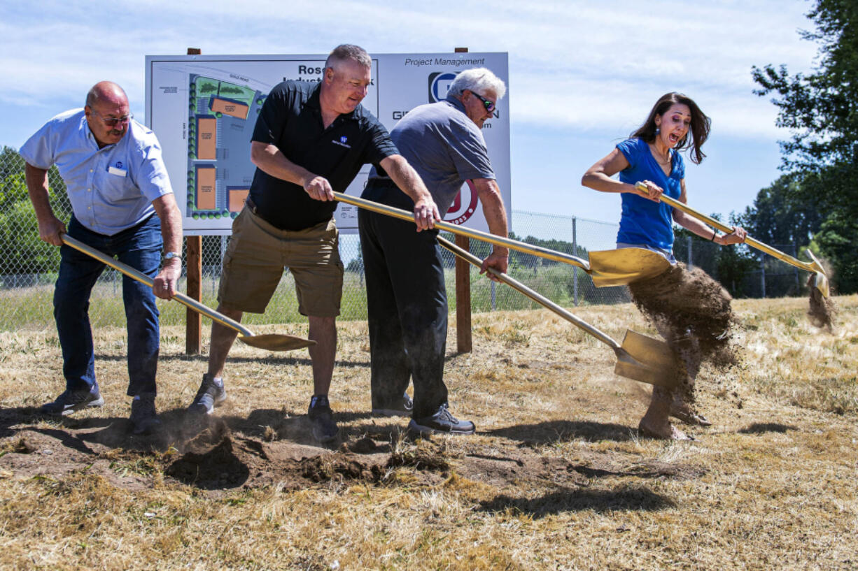 U.S. Rep. Jaime Herrera Beutler, R-Battle Ground, jumps June 4 to avoid dirt thrown by Port of Woodland Commissioner Dale Boon, left, Port of Woodland Commission President Bob Wile, second from the left, and Port of Woodland Commissioner Paul Cline.