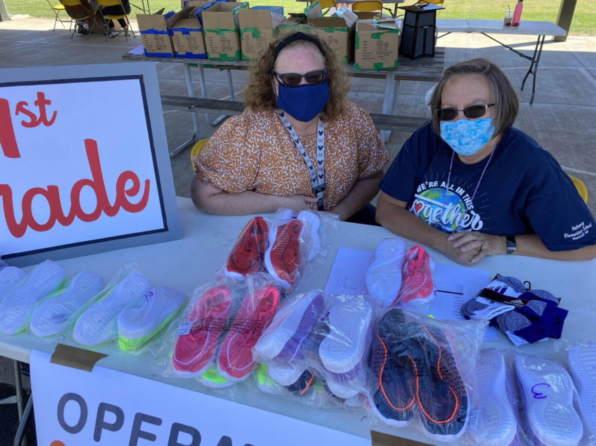 WASHOUGAL: Penny Porche and Nancy Boon, Washougal School District family resource coordinators, helped students pick up their new shoes at the Shoe-a-palooza event.