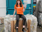 Taylor Loewen, Southwest Washington manager for Ridwell, sits on a bale of clamshells collected for recycling by Green Impact Plastics. Ridwell, which collects hard-to-recycle items, is launching service in Vancouver, Hazel Dell and Salmon Creek.