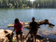 Chloe, 10, left, and Van Hoots, 12, of Salmon Creek, stand on the shores of Battle Ground Lake to fish in June 2021 at Battle Ground Lake State Park.