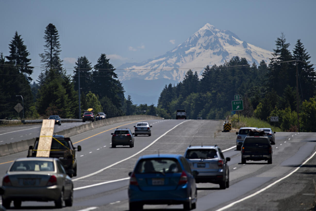 Drivers traveling east on state Highway 14 take in a scenic view as a snowcapped Mount Hood is seen in the distance under sunny skies Thursday. Forecasters expect sunny skies and summer-like temperatures for several days, with temperatures peaking near  100 degrees on Monday.