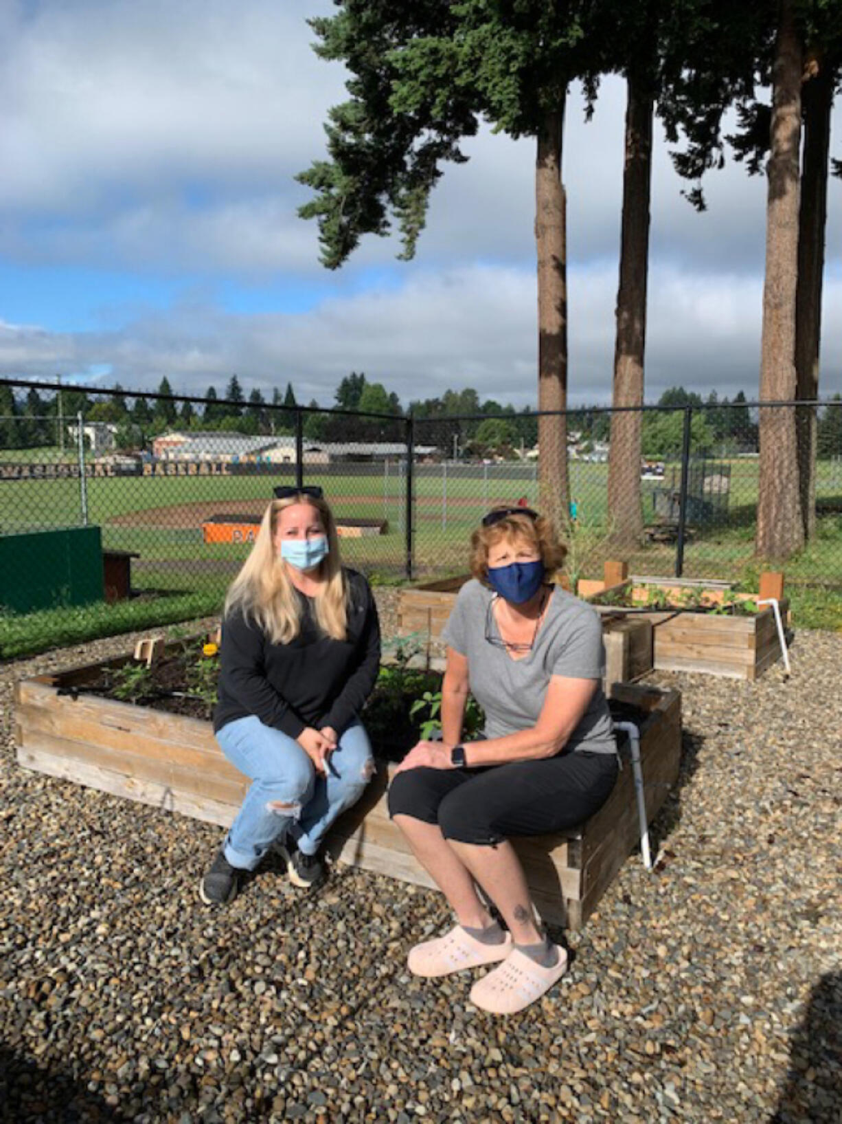 WASHOUGAL: Community member Nicole King and Washougal High School Chef Brenda Hitchins, right, take a seat on some of the school's new raised garden beds.