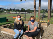 WASHOUGAL: Community member Nicole King and Washougal High School Chef Brenda Hitchins, right, take a seat on some of the school's new raised garden beds.