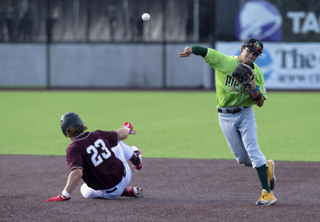 Ridgefield's Tafton Hensley tries to slide to break up a double play converted by Yakima Valley shortstop Connor Caballes with this throw in Tuesday's West Coast League baseball game at the Ridgefield Outdoor Recreation Complex.