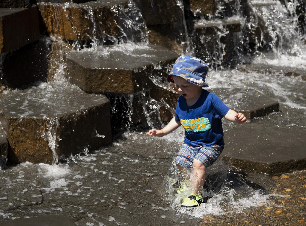 Robin Lester, 2, jumps into the shallow water to make a splash on Friday, June 25, 2021, at the Esther Short Water Feature.