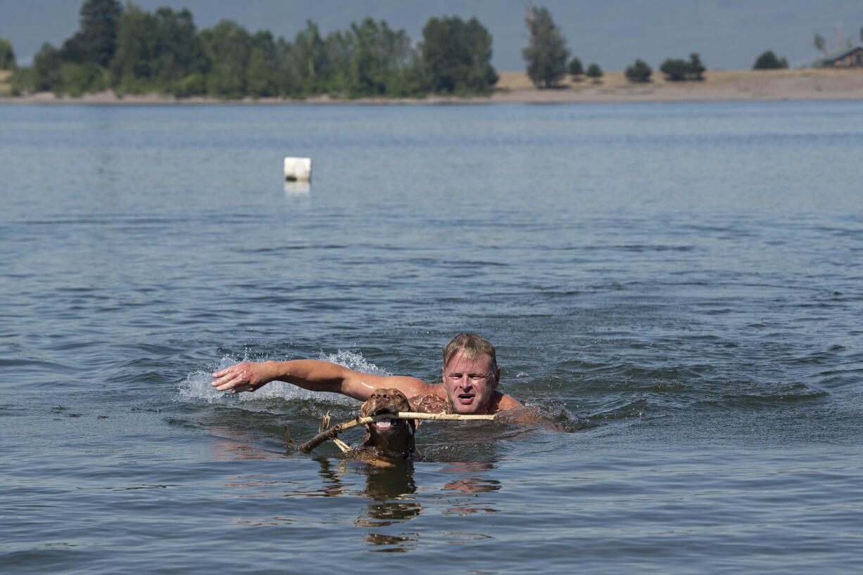 Kurt Vigeland of Vancouver cools off at Frenchmans Bar Regional Park while playing with family dog, Vita, 4, as temperatures soar on Monday morning, June 28, 2021.