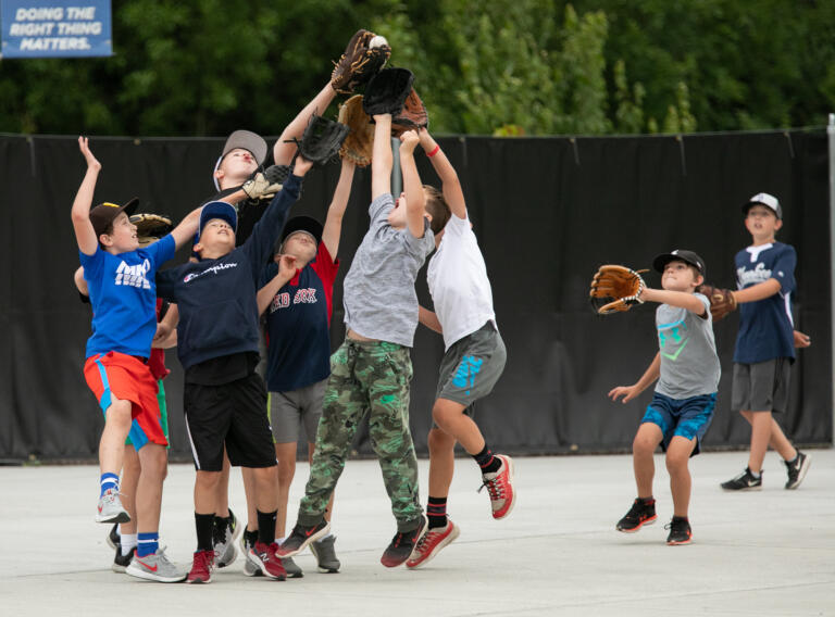 Kids play catch in the fan section as Ridgefield takes on Bellingham in a West Coast League baseball game at the Ridgefield Outdoor Recreation Complex on Wednesday, June 30, 2021.