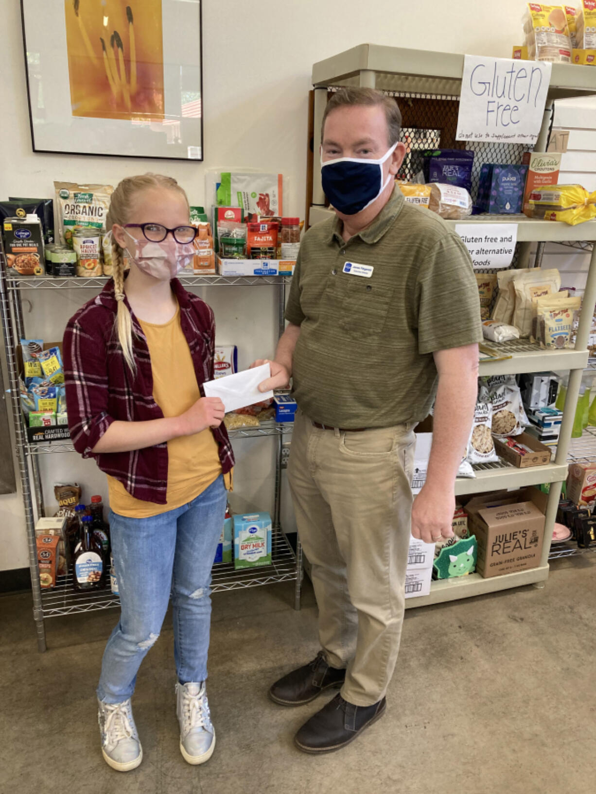 ESTHER SHORT: James Fitzgerald, executive director of nonprofit organization FISH of Vancouver, accepts a donation from 10-year-old Chloe Daarud.