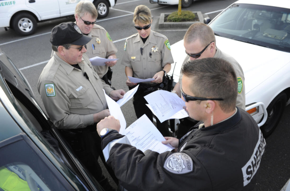 Clark County Sheriff's Reserve deputies from left,  Daryl Arndt, Rich Wilson, Deborah Wonderly, Ed Bausch, and Shane Joachim plan their coverage for a half marathon community run in Vancouver in April 2012.