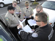 Clark County Sheriff's Reserve deputies from left,  Daryl Arndt, Rich Wilson, Deborah Wonderly, Ed Bausch, and Shane Joachim plan their coverage for a half marathon community run in Vancouver in April 2012.