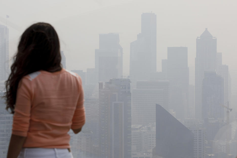 A woman looks at the skyline from the Space Needle observation deck on Monday, August 20, 2018 in Seattle.