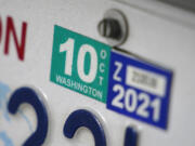 A Washington state car registration tab is shown on a vehicle in Olympia.