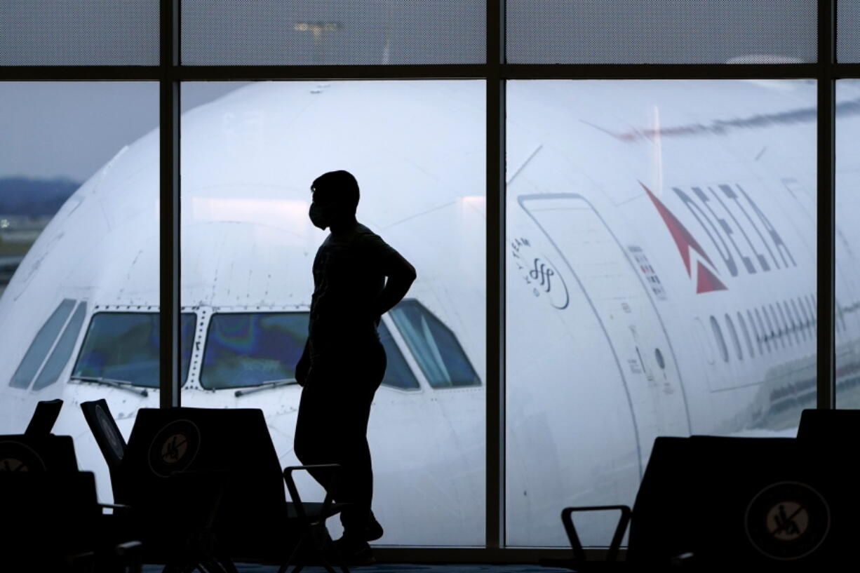 FILE - In this Feb. 18, 2021 file photo, a passenger wears a face mask to help prevent the spread of the new coronavirus as he waits for a Delta Airlines flight at Hartsfield-Jackson International Airport in Atlanta.  Airlines have reported about 3,000 cases of disruptive passengers since Jan. 1, according to a spokesman for the Federal Aviation Administration. It has gotten so bad that the airlines, flight attendants and pilots sent a letter to the U.S.