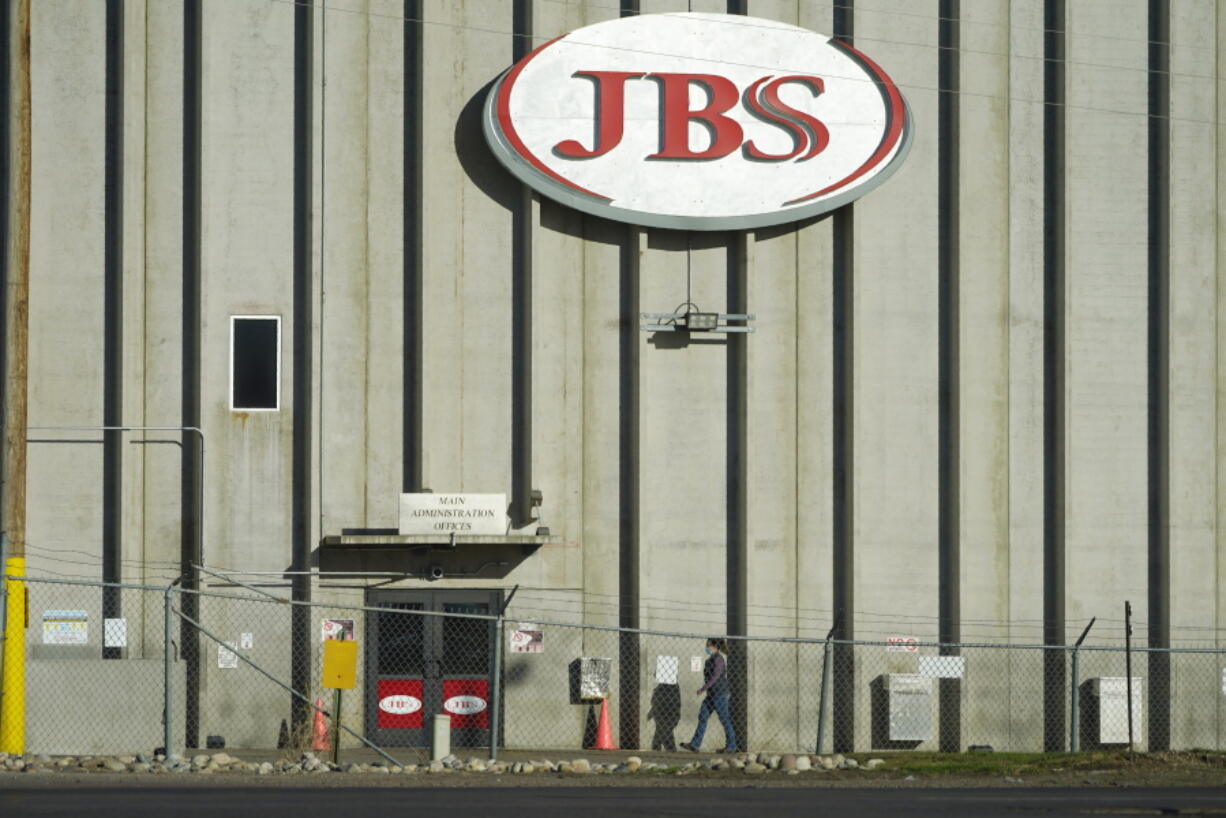 FILE - In this Oct. 12, 2020 file photo, a worker heads into the JBS meatpacking plant in Greeley, Colo.  A weekend ransomware attack on the world's largest meat company is disrupting production around the world just weeks after a similar incident shut down a U.S. oil pipeline. The White House confirms that Brazil-based meat processor JBS SA notified the U.S. government Sunday, May 30, 2021, of a ransom demand from a criminal organization likely based in Russia.