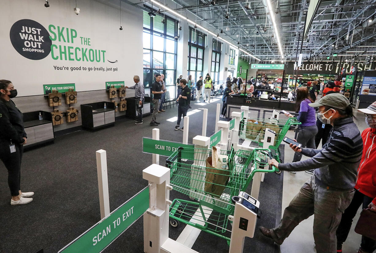 Customers using cashierless technology to checkout with an app or credit card at the first Amazon Fresh in Washington, on opening day, Thursday, June 17, 2021 in Bellevue. The store also has cashiers.