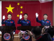 Chinese astronauts, from left, Tang Hongbo, Nie Haisheng, and Liu Boming wave at a press conference at the Jiuquan Satellite Launch Center ahead of the Shenzhou-12 launch from Jiuquan in northwestern China, Wednesday, June 16, 2021. China plans on Thursday to launch three astronauts onboard the Shenzhou-12 spaceship, who will be the first crew members to live on China's new orbiting space station Tianhe, or Heavenly Harmony from the Jiuquan Satellite Launch Center in northwest China.