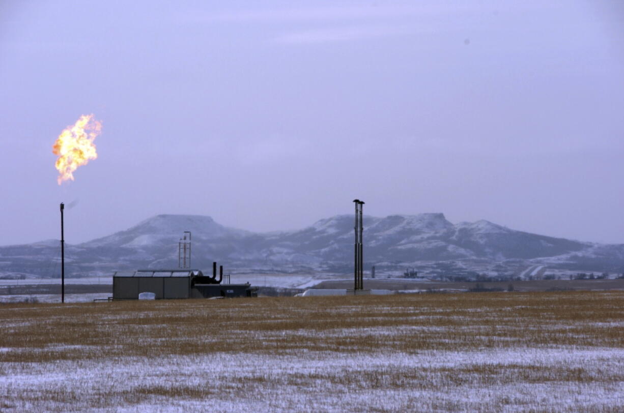 FILE - In this Feb. 25, 2015, file photo, a gas flare is seen at a natural gas processing facility near Williston, N.D. Congressional Democrats have approved a measure reinstating rules aimed at limiting climate-warming greenhouse gas emissions from oil and gas drilling, a rare effort by Democrats to use the legislative branch to overturn a regulatory rollback under President Donald Trump. The House gave final legislative approval Friday, June 25, to a resolution that would undo a Trump-era environmental rule that relaxed requirements of a 2016 Obama administration rule targeting methane emissions from oil and gas drilling..