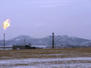 FILE - In this Feb. 25, 2015, file photo, a gas flare is seen at a natural gas processing facility near Williston, N.D. Congressional Democrats have approved a measure reinstating rules aimed at limiting climate-warming greenhouse gas emissions from oil and gas drilling, a rare effort by Democrats to use the legislative branch to overturn a regulatory rollback under President Donald Trump. The House gave final legislative approval Friday, June 25, to a resolution that would undo a Trump-era environmental rule that relaxed requirements of a 2016 Obama administration rule targeting methane emissions from oil and gas drilling..