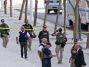 FILE - In this Sept. 15, 2020, file photo, federal law enforcement personnel patrol outside the Sandra Day O'Connor Federal Courthouse in Phoenix. The U.S. Marshals Service lacks the capability of adequately detecting threats against federal judges across the nation and uses outdated security equipment to protect judges' homes, the Justice Department's inspector general said Wednesday.  (AP Photo/Ross D.