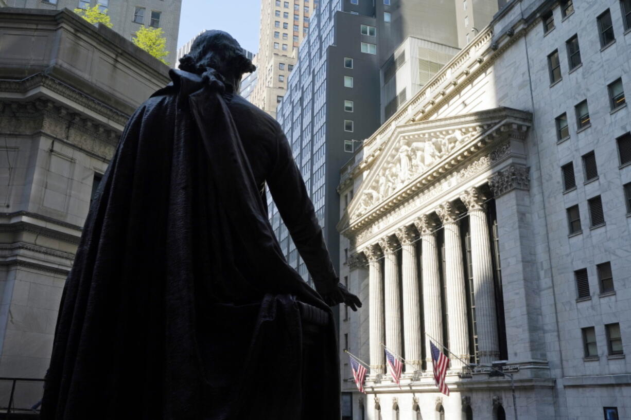 FILE - In this June 7, 2021 file photo, the Federal Hall statue of George Washington overlooks the New York Stock Exchange.   Stocks are opening higher on Wall Street, Tuesday, June 29, led by gains in major banks after many of them announced plans to return billions more to their shareholders in the form of dividends and stock buybacks.