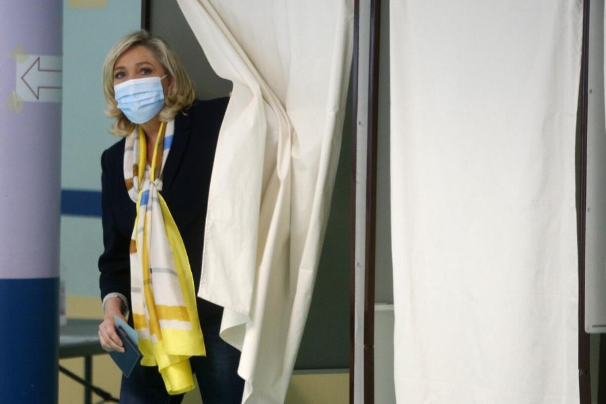 Far-right leader Marine Le Pen leaves the voting booth before voting for the regional elections in Henin-Beaumont, northern France, Sunday, June 27, 2021. A decisive, second round of voting in regional elections in France on Sunday is being scrutinized as a litmus test of whether the anti-immigration far right is gaining in acceptability and electability ahead of the French presidential election next year.