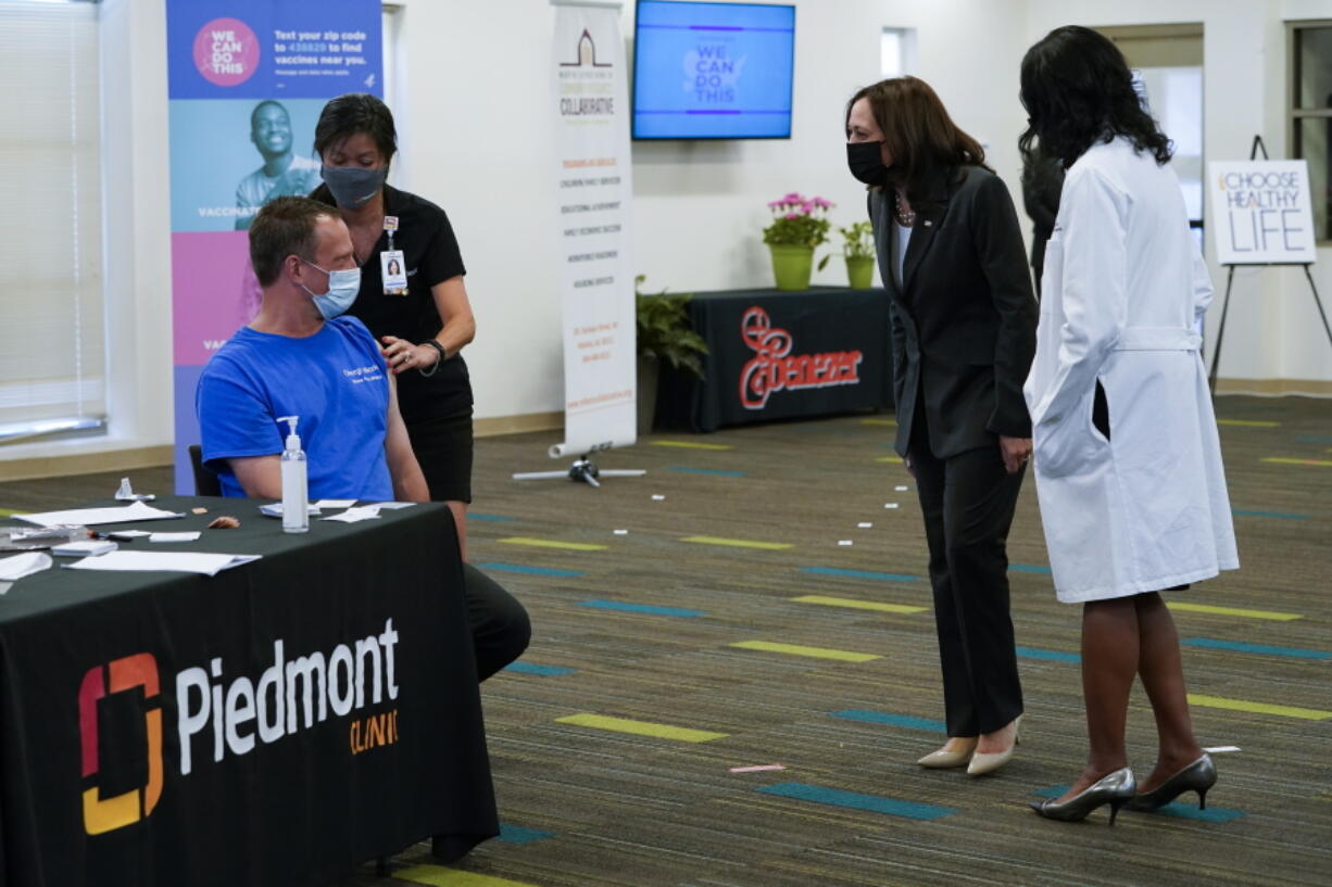 Vice President Kamala Harris talks to a man as he receives a COVID-19 vaccine at a COVID-19 pop-up center at Ebenezer Baptist Church, Friday, June 18, 2021, in Atlanta.