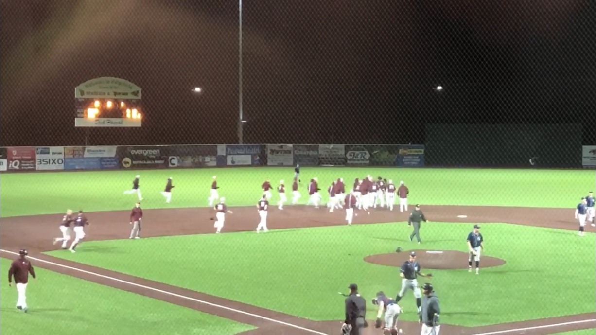 The Ridgefield Raptors mob hitter John Peck after his game-winning double in the 13th inning of a 10-9 win over the Portland Pickles on Thursday in Ridgefield.