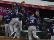 Seattle Mariners designated hitter Jake Fraley (28) celebrates with J.P. Crawford (3) after hitting a grand slam home run during the fourth inning of a baseball game against the Los Angeles Angels Saturday, June 5, 2021, in Anaheim, Calif. Mitch Haniger, Ty France, and Taylor Trammell also scored.