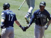 Seattle Mariners' Donovan Walton, right, gets congratulations from Mitch Haniger, after Walton hits a solo home run against the Los Angeles Angels during the third inning of a baseball game in Anaheim, Calif., Sunday, June 6, 2021.