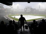 A tarp covers the infield as fans wait during a rain delay before a baseball game between the Seattle Mariners and the Chicago White Sox in Chicago, Saturday, June 26, 2021. (AP Photo/Nam Y.