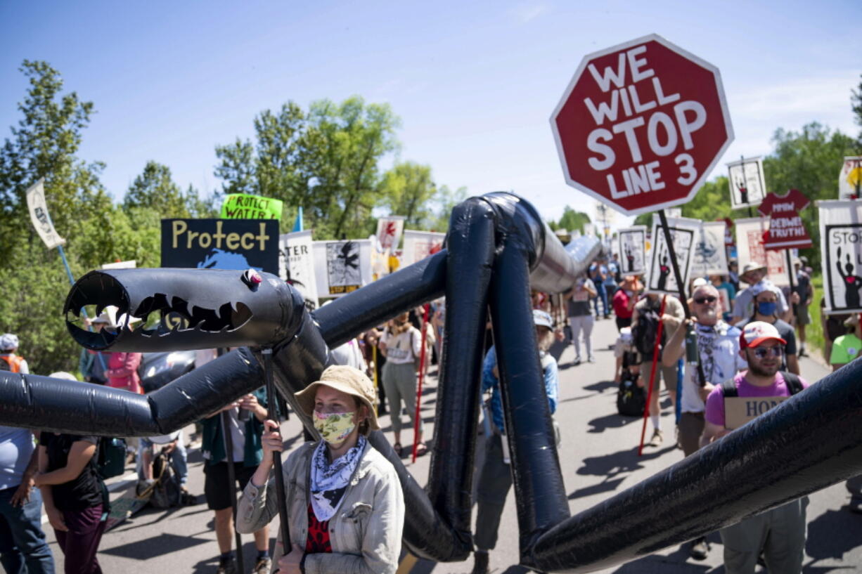 A makeshift "black snake" resembling a pipeline is carried as demonstrators march along Highway 9, on Monday, June 7, 2021, in Clearwater County, Minn. More than 2,000 Indigenous leaders and "water protectors" gathered in Clearwater County from around the country to protest the construction of Enbridge Line 3. The day started with a prayer circle and moved on to a march to the Mississippi headwaters where the oil pipeline is proposed to be built.