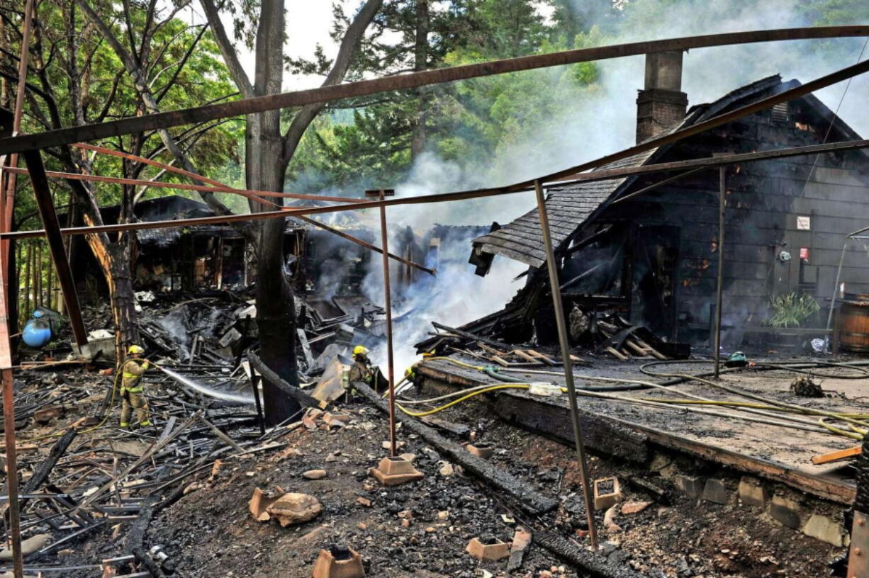 Smoke rises Tuesday from the ruins of the Galice Resort west of Grants Pass, Ore., after a morning blaze. The resort's restaurant, store and boat shed were destroyed.