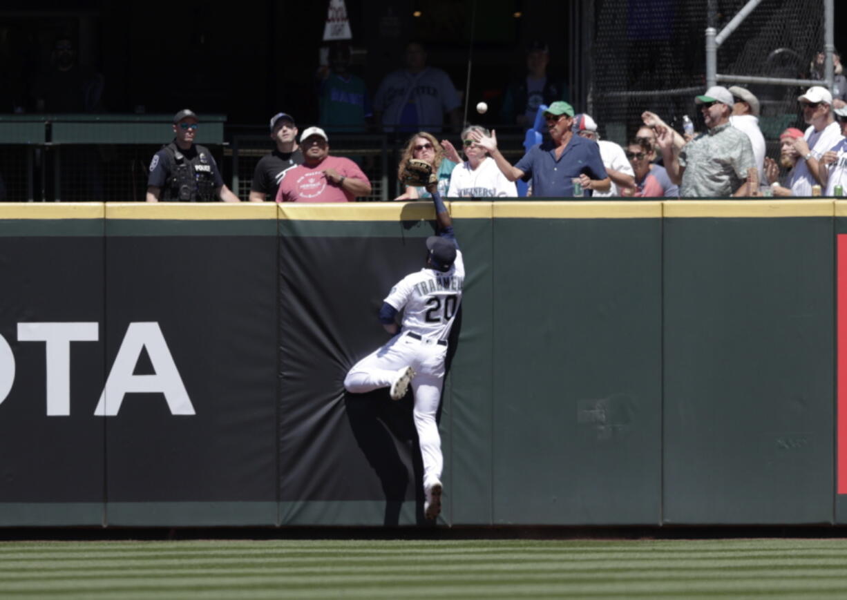 The home run ball hit by Colorado Rockies' Brendan Rodgers bounces among fans in the stands with Seattle Mariners center fielder Taylor Trammell leaping during the second inning of a baseball game, Wednesday, June 23, 2021, in Seattle.